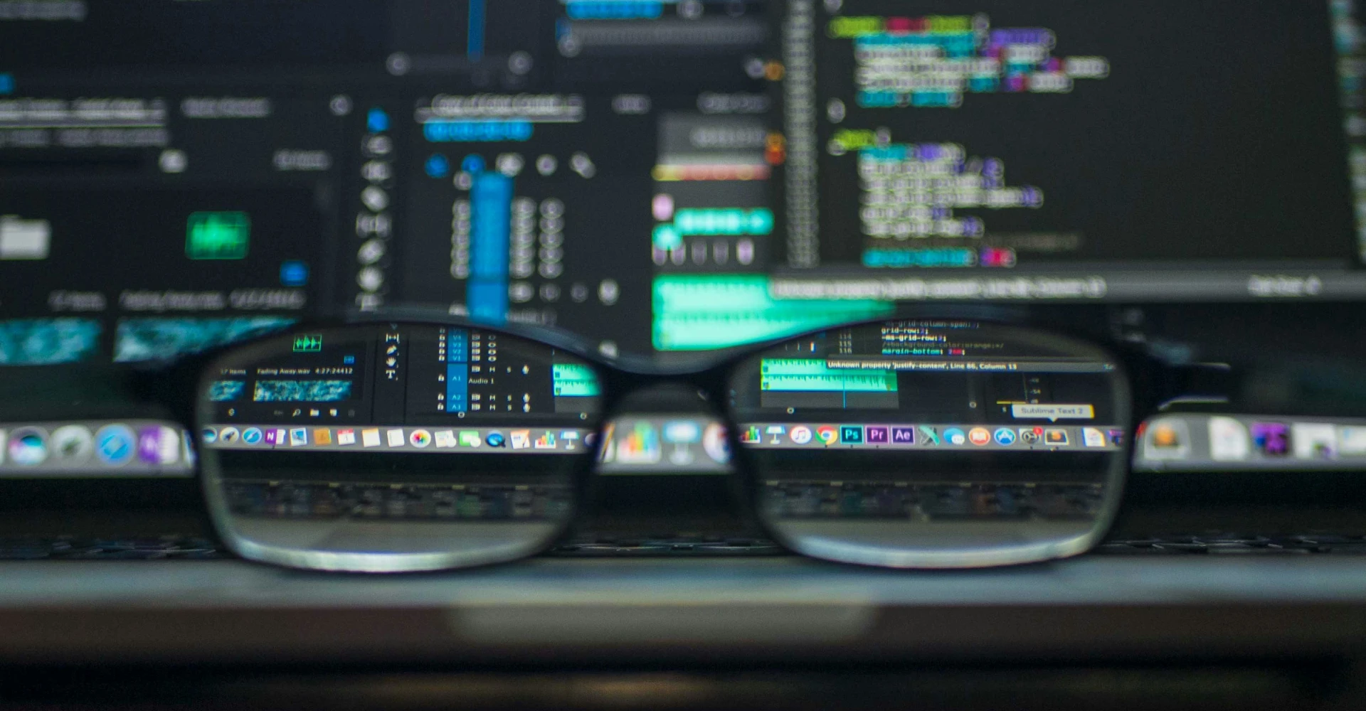 pair of glasses in front of a computer screen
