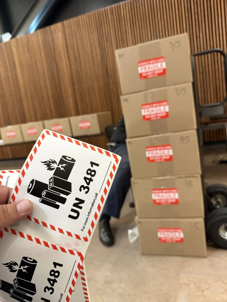 computer equipment stacked in boxes. UN 3481 materials label